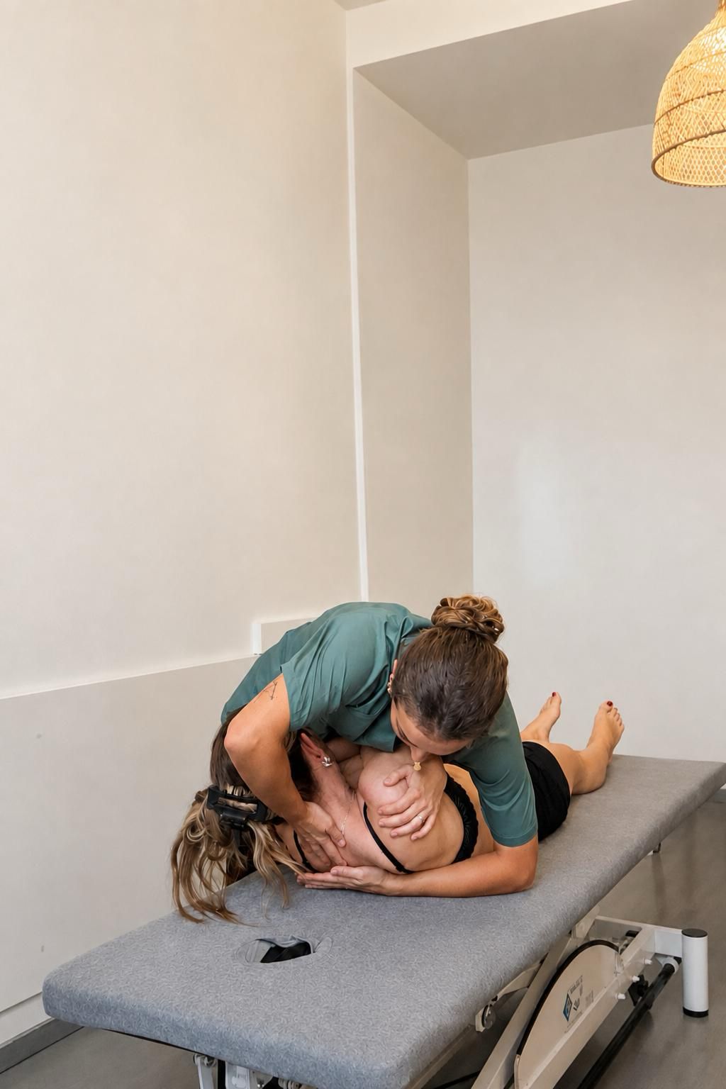 Technique ostéopathique sur le rachis dorsal, patiente allongée sur le ventre